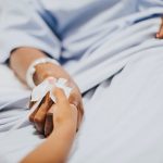 Daughter holding  her mothers hand in the hospital